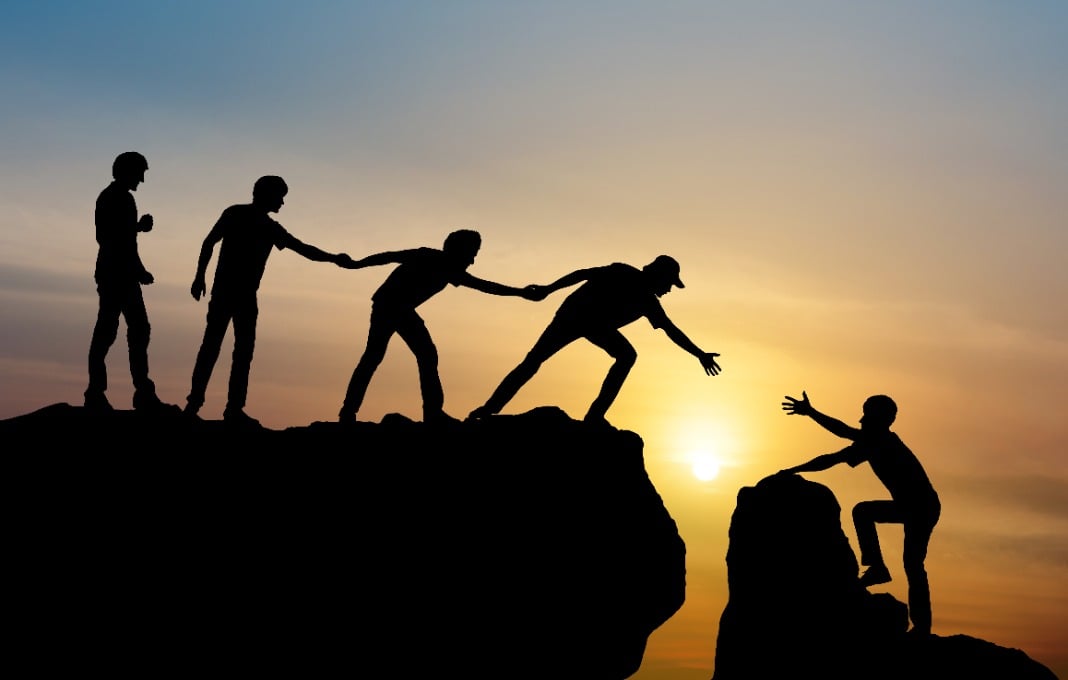Group of people on peak mountain climbing helping team work