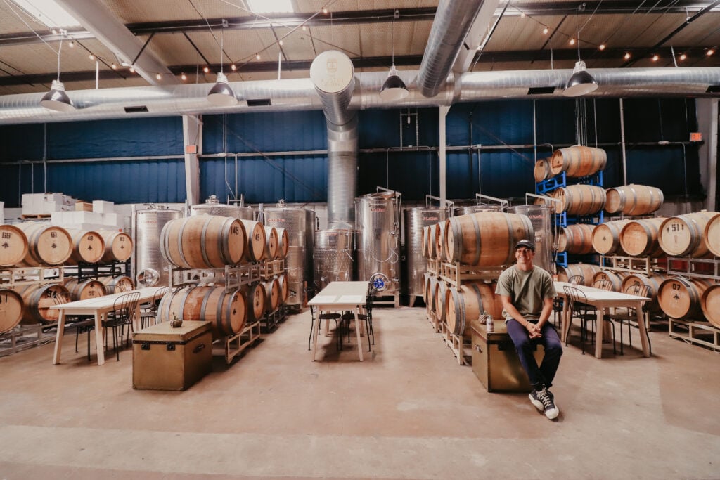 Austin Winery founder in urban winery with wine barrels